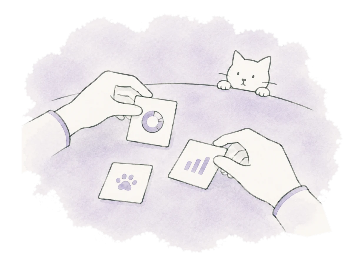 Hands arrange small chart cards while a cat looks on.