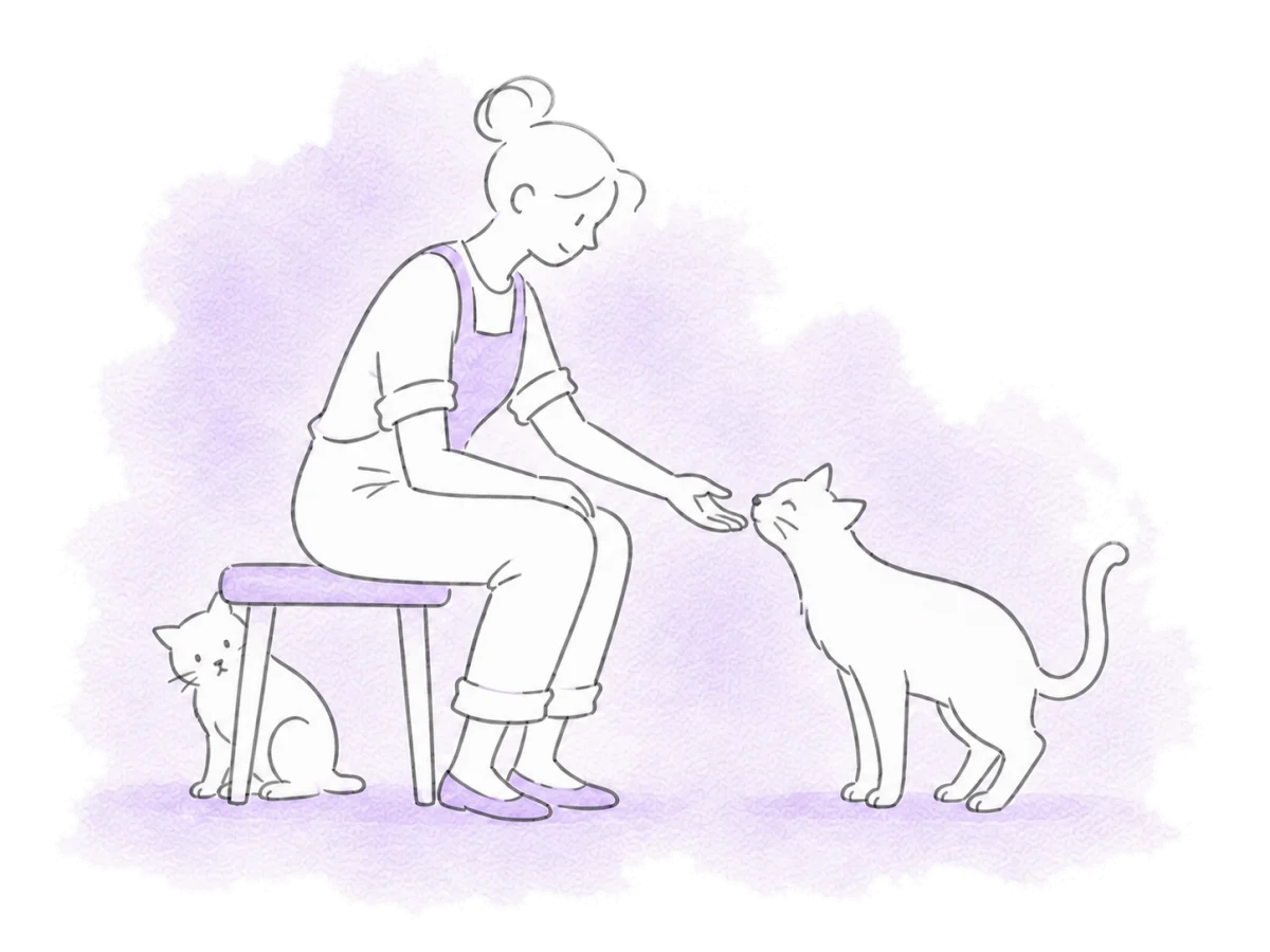 A patient volunteer lets a friendly cat approach while a shy cat keeps its distance.