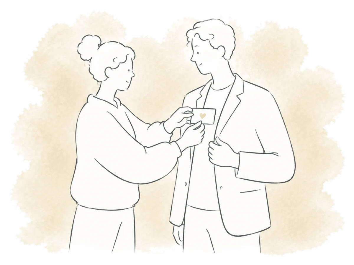 One volunteer helps another put on a name badge.