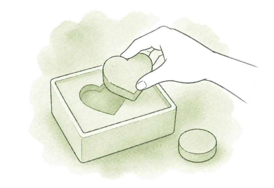 A hand fits a heart-shaped piece into its matching opening.