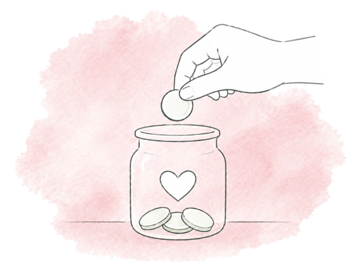 A hand adds a coin to a small heart-marked giving jar.