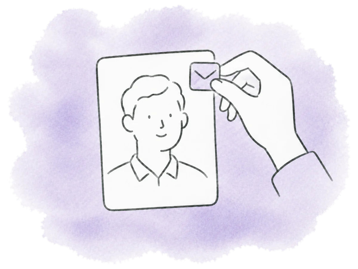 A hand attaches a small envelope badge to a person’s card.