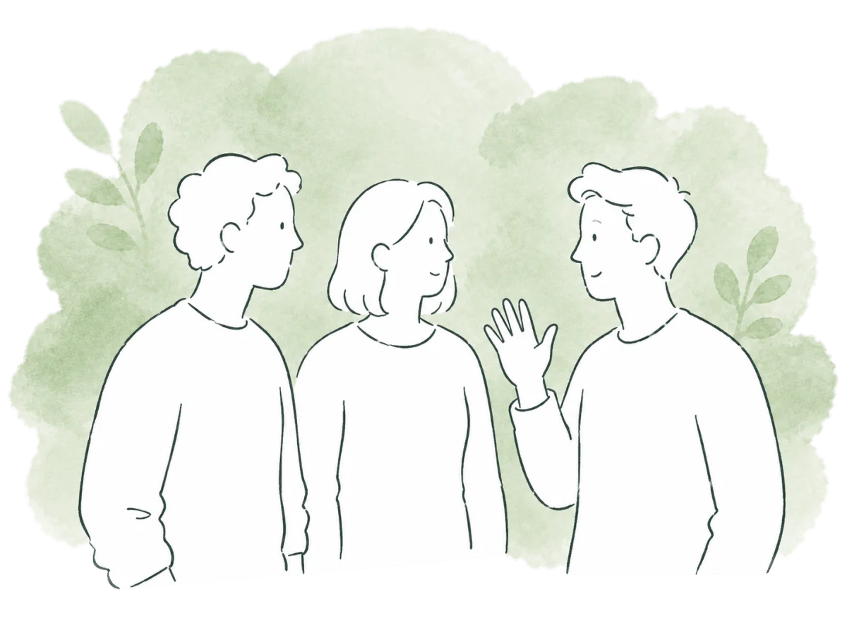 Three volunteers stand in a loose semicircle, greeting one another.