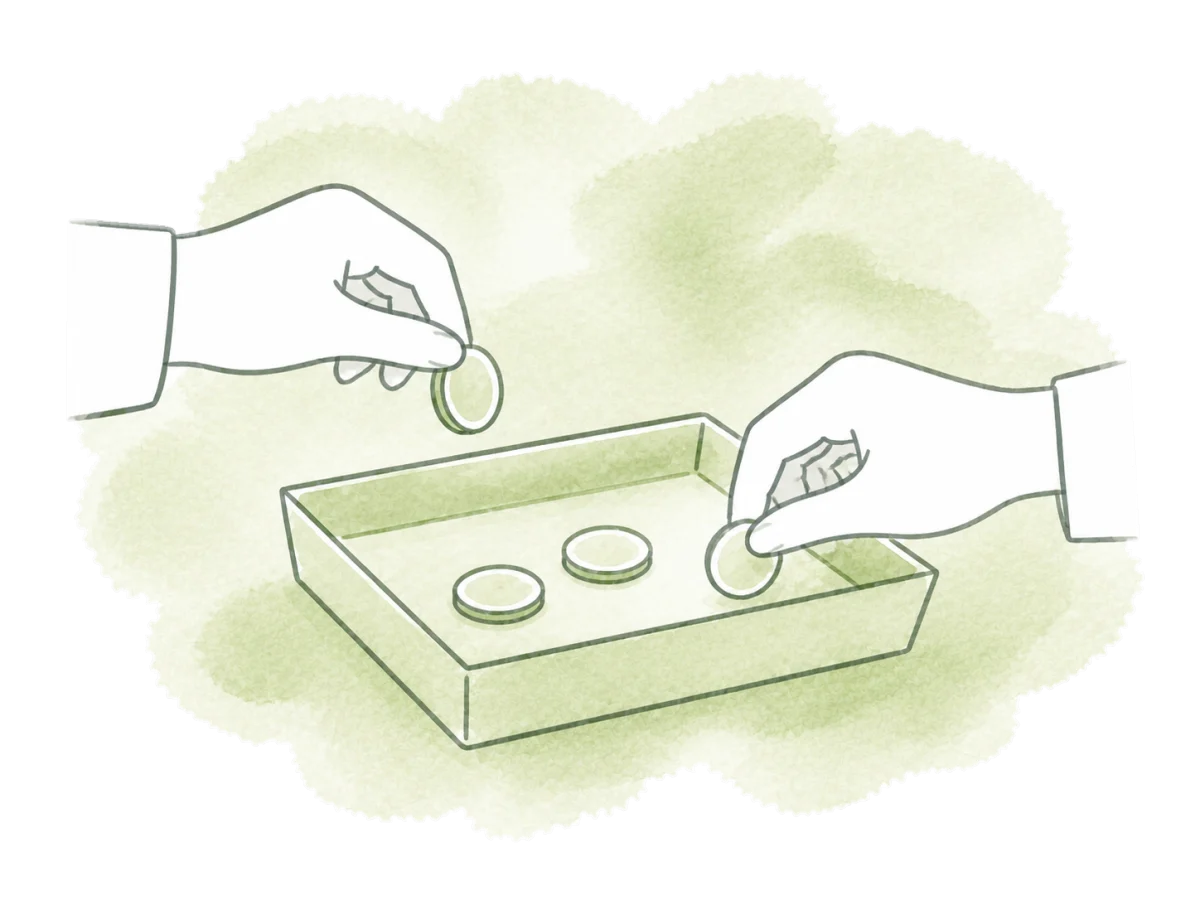 Hands place coins into and take coins from one small cash tray.