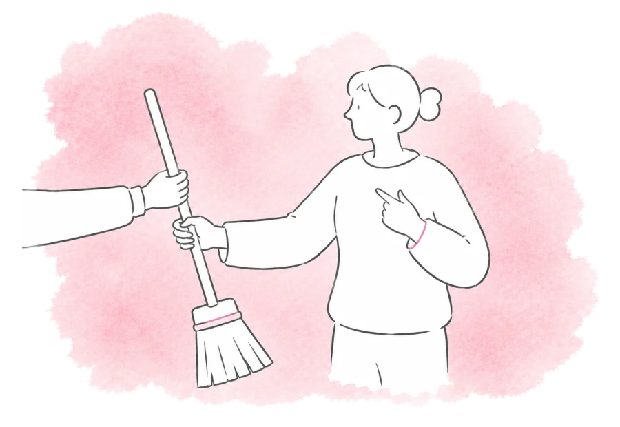 A volunteer takes the broom for their part of the work.